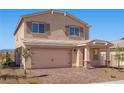 Charming two-story home featuring a brick driveway and a tan exterior at 6773 Violet Cascade Ave, Las Vegas, NV 89156