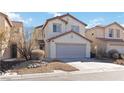 Beige two-story home featuring a two-car garage and low-maintenance desert landscaping at 7452 Wine Creek St, Las Vegas, NV 89139