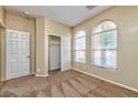 Bright, carpeted bedroom featuring two arched windows, a closet, and neutral paint throughout at 10383 Gwynns Falls St, Las Vegas, NV 89183