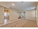 Spacious living room with carpet flooring, tile flooring, neutral paint, and staircase leading to the second floor at 10383 Gwynns Falls St, Las Vegas, NV 89183