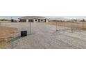 View of a residential home with minimalist front yard and chain-link fence in a desert community at 1601 W Calvada Blvd, Pahrump, NV 89048