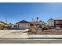 Inviting single-story home featuring mature desert landscaping and an expansive driveway leading to a two-car garage at 2375 Rawhide St, Las Vegas, NV 89119