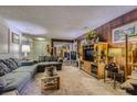 Cozy living room featuring wood-paneled walls, comfortable sofas, carpeted floors, and ample natural light at 2375 Rawhide St, Las Vegas, NV 89119