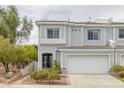 Stylish townhome features gray exterior, a two-car garage, and tasteful landscaping for a welcoming curb appeal at 2405 Esteem Ridge Dr, Henderson, NV 89052