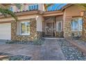 Charming home featuring a secure gated entrance, stone accents, and manicured landscaping at 2529 Vera Cruz Cir, Henderson, NV 89074