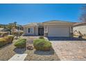 Inviting single-story home with a brick driveway and well-maintained desert landscaping at 2705 Cuckoo Shrike Ave, North Las Vegas, NV 89084