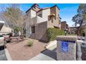Two-story tan condo with stucco, red-tile roof, well-maintained landscaping, and reserved parking at 2966 Juniper Hills Blvd # 204, Las Vegas, NV 89142