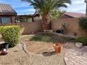 Backyard featuring desert landscaping, rock border, brick patio, potted plants, and block wall at 37 Buffalo Gap Ct, North Las Vegas, NV 89084