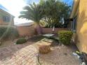 Private backyard featuring desert landscaping, brick patio, large palm tree and table at 37 Buffalo Gap Ct, North Las Vegas, NV 89084