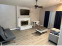 Cozy living room with painted brick fireplace, wood floors, and stylish furniture at 3908 Redwood St, Las Vegas, NV 89103