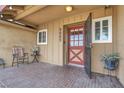 Inviting front porch features an outdoor seating area and a decorative front door at 5005 Harmony Ave, Las Vegas, NV 89107