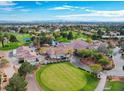 Breathtaking aerial view of a lush golf course community with clubhouse, golf carts and mature landscaping at 5104 Elm Grove Dr, Las Vegas, NV 89130