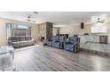 Open-concept living area featuring modern flooring, a stone fireplace, and seamless access to the kitchen at 7817 Aplin Ave, Las Vegas, NV 89145