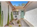 Inviting front courtyard featuring a turquoise door, desert landscaping with cacti, and a warm, welcoming ambiance at 976 El Camino Way, Boulder City, NV 89005