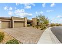 Paver driveway leads to a stylish modern home with a three-car garage and manicured desert landscaping at 10016 Copper Edge Rd, Las Vegas, NV 89148