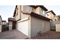 Exterior view showcasing the home's stucco facade, two-car garage, and tile roof at 10596 Corte Sierra St, Las Vegas, NV 89183