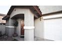 Close up of the covered front entryway featuring a wood front door and stucco pillars at 10596 Corte Sierra St, Las Vegas, NV 89183