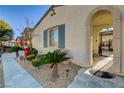 Close-up of desert landscaping and covered entryway with an arched design at front door at 1883 Nature Park Dr, North Las Vegas, NV 89084