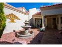 Charming courtyard featuring a decorative fountain, desert landscaping, and a quaint seating area at 2636 Highvale Dr, Las Vegas, NV 89134