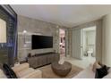 Living room with modern media center, neutral-toned furniture, and a view to a bathroom at 3722 Las Vegas Blvd # 1712, Las Vegas, NV 89158