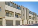 View of modern townhomes featuring garages, balconies, and neutral-toned stucco at 3772 Brilliant Sunset St, Las Vegas, NV 89129