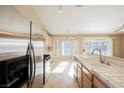 Bright kitchen featuring white cabinets, tile countertops, stainless steel appliances and a dining nook at 4016 Fairport Dr, North Las Vegas, NV 89032