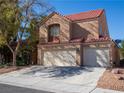 Two-story stucco home with a red tile roof and a three-car garage at 425 Donner Pass Dr, Henderson, NV 89014