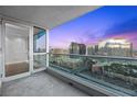 Balcony showcasing a captivating skyline view at twilight through glass railings and sliding glass doors at 4575 Dean Martin Dr # 3009, Las Vegas, NV 89103