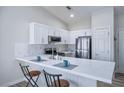 Bright kitchen with white cabinets, stainless steel appliances, a breakfast bar, and marble-look backsplash at 4980 Black Bear Rd # 104, Las Vegas, NV 89149