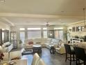 Bright, open-concept living room featuring tile floors, a modern ceiling fan, and lots of windows for natural light at 5320 Tartan Hill Ave, Las Vegas, NV 89141