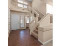 Bright foyer showcasing tile floors, staircase, and front door leading to powder room at 5971 Sonoma Station Ave, Las Vegas, NV 89139