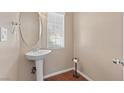 Cozy powder room featuring a pedestal sink, neutral walls, and a window providing natural light at 5971 Sonoma Station Ave, Las Vegas, NV 89139