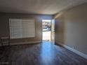 Living room with wood-look floors, bright windows with blinds, and neutral paint at 615 S Royal Crest Cir # 15, Las Vegas, NV 89169