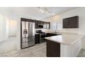 Modern kitchen with stainless steel appliances, dark wood cabinets, and a breakfast bar at 6314 Ruby Cedar Ct, North Las Vegas, NV 89031