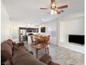 Spacious open-concept living area with a ceiling fan, neutral tile flooring, and lots of natural light at 6314 Ruby Cedar Ct, North Las Vegas, NV 89031