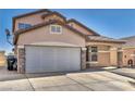 Two-story home with a wide driveway and two-car garage with brick and stone accents at 7308 Alpine Ridge St, Las Vegas, NV 89131