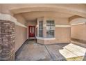 Covered front porch featuring stone columns and a red front door with decorative window panes at 7308 Alpine Ridge St, Las Vegas, NV 89131