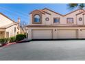 Delightful townhome featuring a two-car garage, desert landscaping, and charming architectural details at 8301 Boseck Dr # 215, Las Vegas, NV 89145