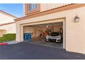 Spacious two-car garage featuring ample storage, side door access, and a sleek white car parked inside at 8301 Boseck Dr # 215, Las Vegas, NV 89145