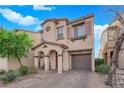 Inviting home featuring a private garage and brick driveway leading to the arched covered porch entry at 8349 Spruce Bay Ave, Las Vegas, NV 89178