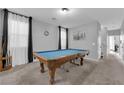 Spacious game room featuring a pool table, neutral carpet, and lots of natural light at 8349 Spruce Bay Ave, Las Vegas, NV 89178