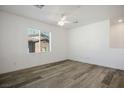 Bedroom features wood-look floors, a ceiling fan, and a window letting in natural light at 965 Nevada State Dr # 39201, Henderson, NV 89002