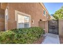 A glimpse of the side and back exterior featuring a gate and stucco walls, providing privacy and charm at 9655 Idle Spurs Dr, Las Vegas, NV 89123