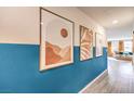 Stylish entryway with eye-catching blue accent wall and decorative artwork leading to a naturally lit living space at 10148 Mulberry Ridge St # 38, Las Vegas, NV 89141