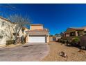 Tan two-story home featuring a two car garage, desert landscaping, and a secure side gate at 1016 Douglas Flat Pl, Las Vegas, NV 89138