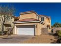 View of the two-story home with a two car garage and easy to maintain desert landscaping at 1016 Douglas Flat Pl, Las Vegas, NV 89138