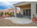 Back patio with concrete tiles featuring furniture and mature landscaping at 10320 Bent Brook Pl, Las Vegas, NV 89134