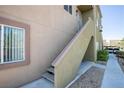 Exterior staircase leading up to a condo with neutral color scheme and desert landscaping at 1844 N Decatur Blvd # 203, Las Vegas, NV 89108