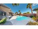 Private backyard oasis with a pool, spa, palm trees, and lounge chairs at 2713 Tanagrine Dr, North Las Vegas, NV 89084