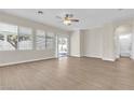 Light-filled living room boasts wood floors, neutral walls, large windows, and sliding door access to the backyard at 5323 Farley Feather Ct, North Las Vegas, NV 89031